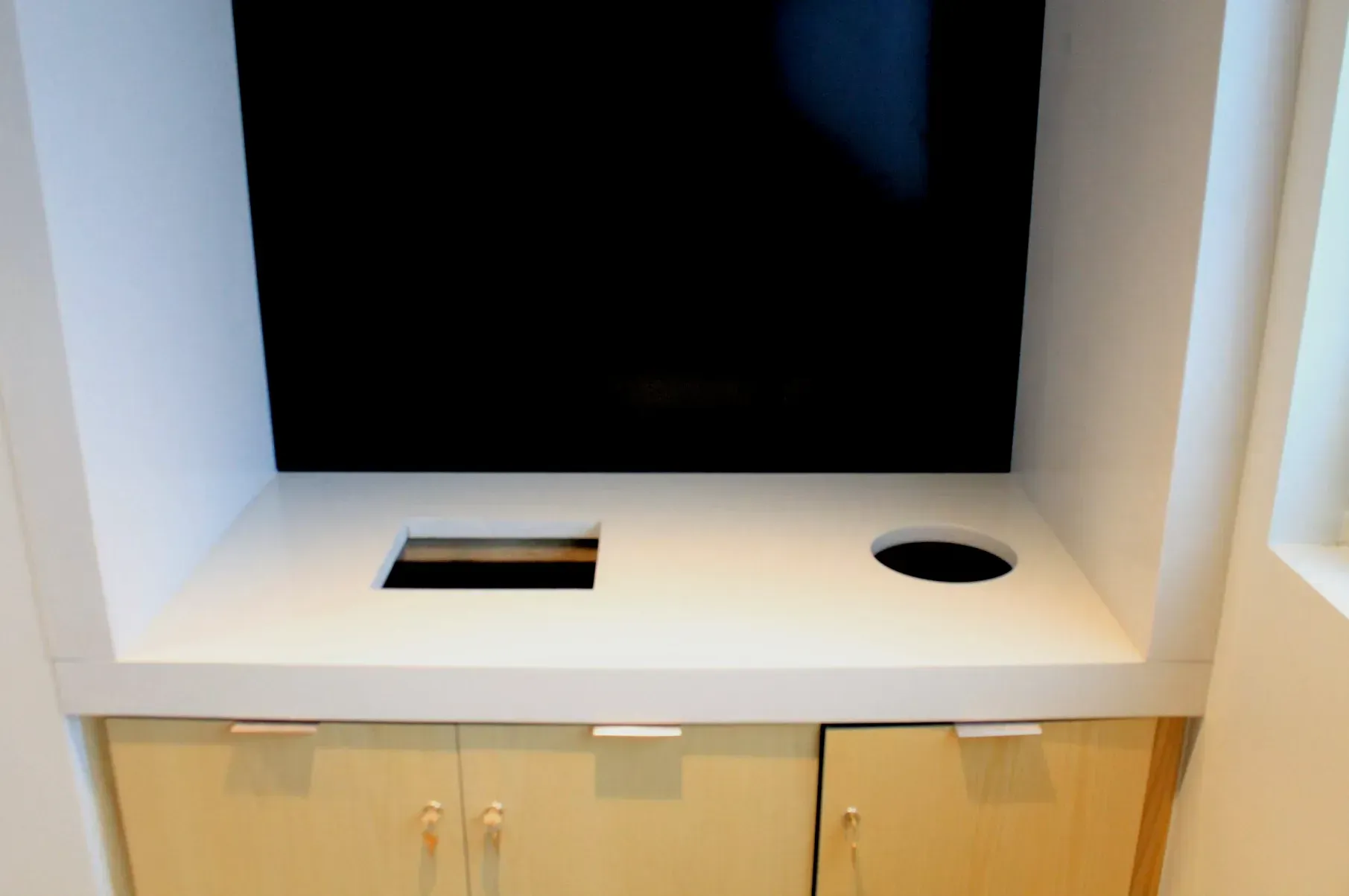 A shelf with a black screen and a hole in it