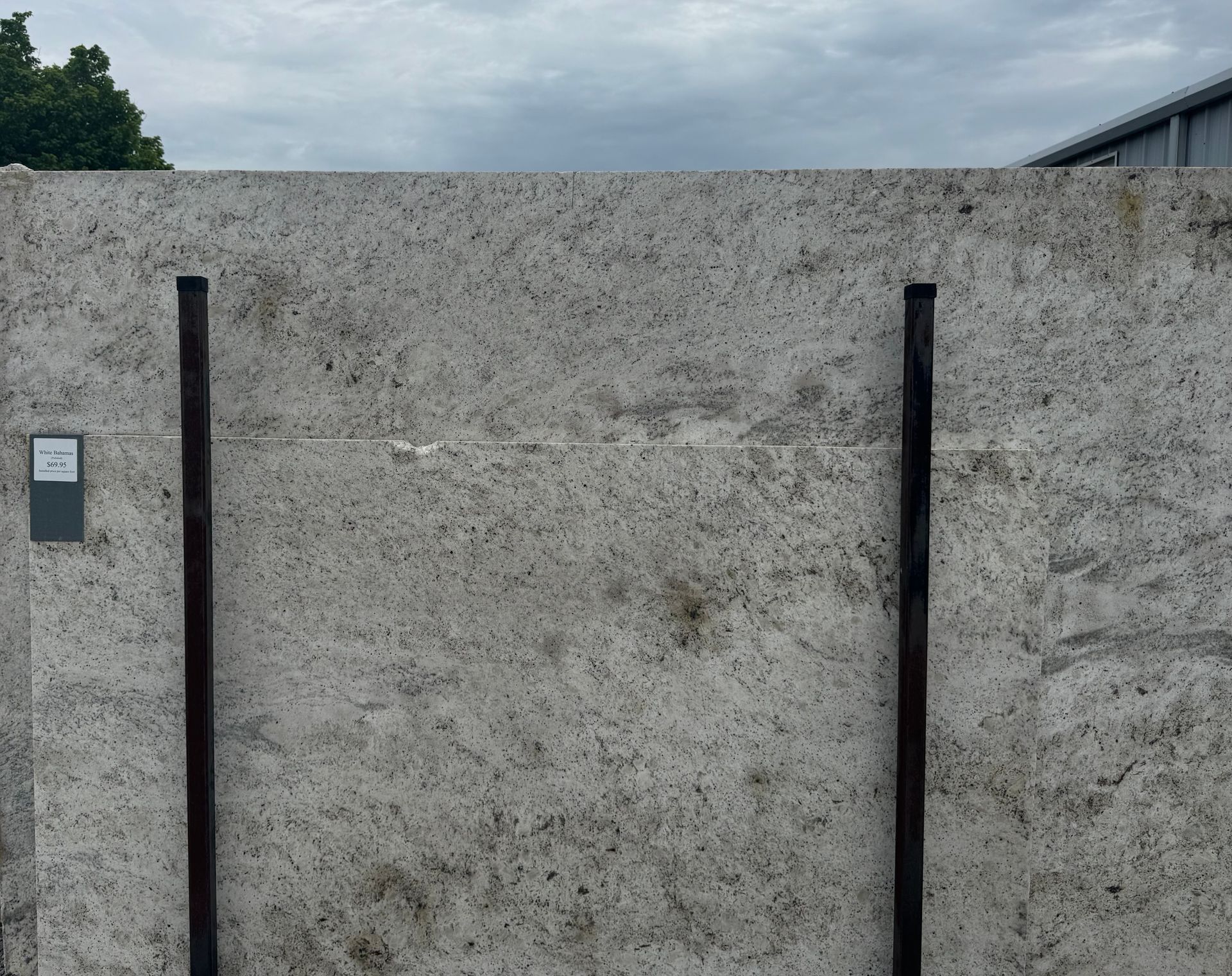 A concrete wall with two metal poles in front of it