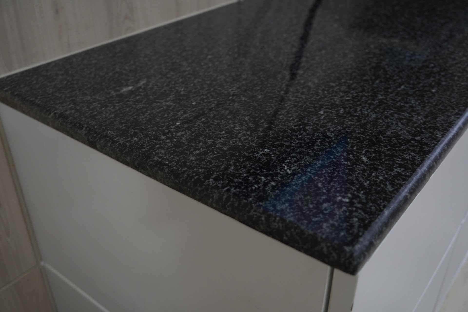 Close-up of the corner of a black quartz countertop.