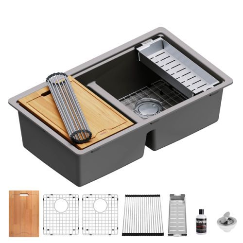 Gray double-basin kitchen sink with accessories: cutting board, dish rack, and drain grids.