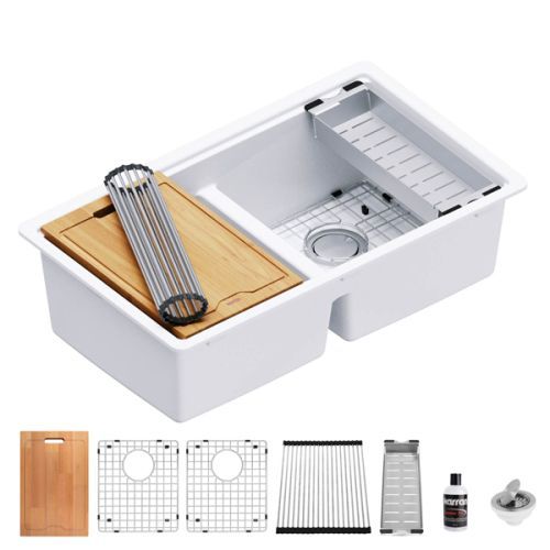 White double-basin kitchen sink with included accessories: cutting board, dish rack, and drain strainer.
