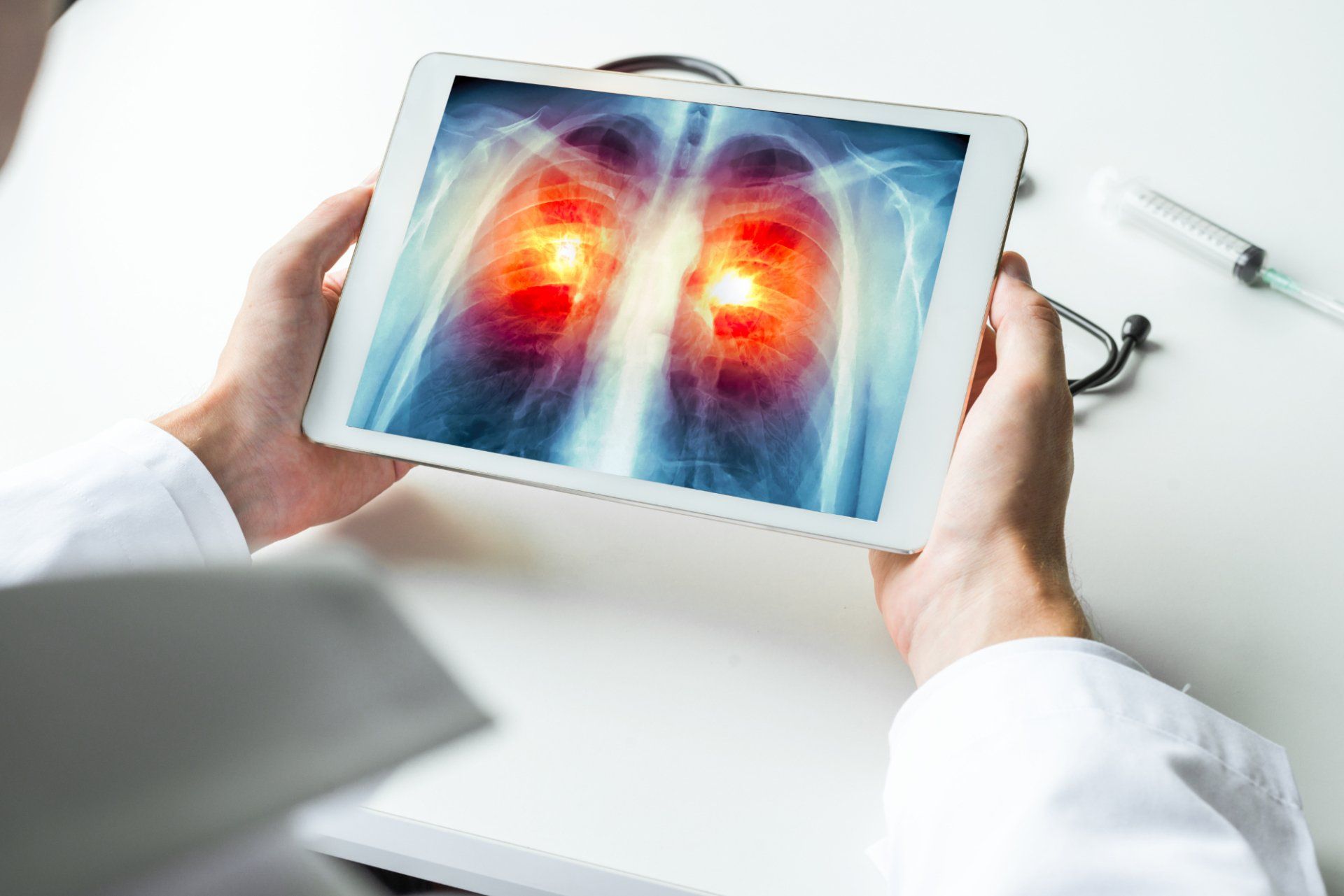 doctor examines lung cancer scan on tablet