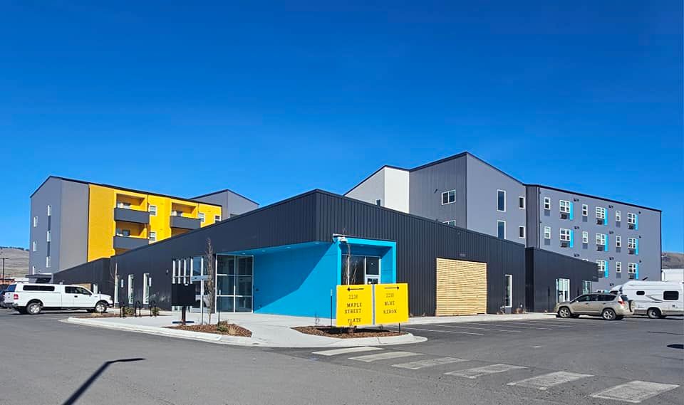 A large building with a lot of cars parked in front of it.