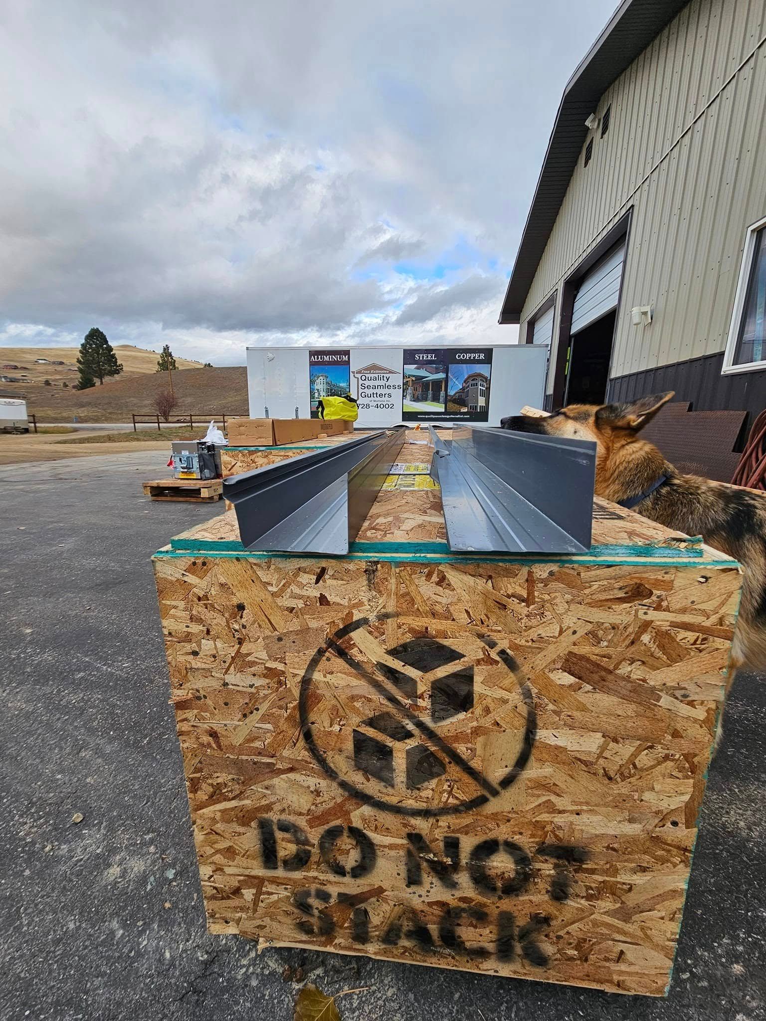 A wooden box with a do not stack sign on it is sitting in front of a building.