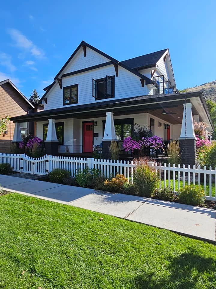 A large white house with a white picket fence and a porch.
