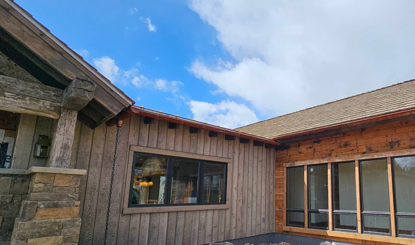 A wooden house with a lot of windows and a blue sky in the background.