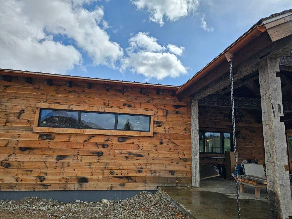A wooden building with a large window on the side of it.