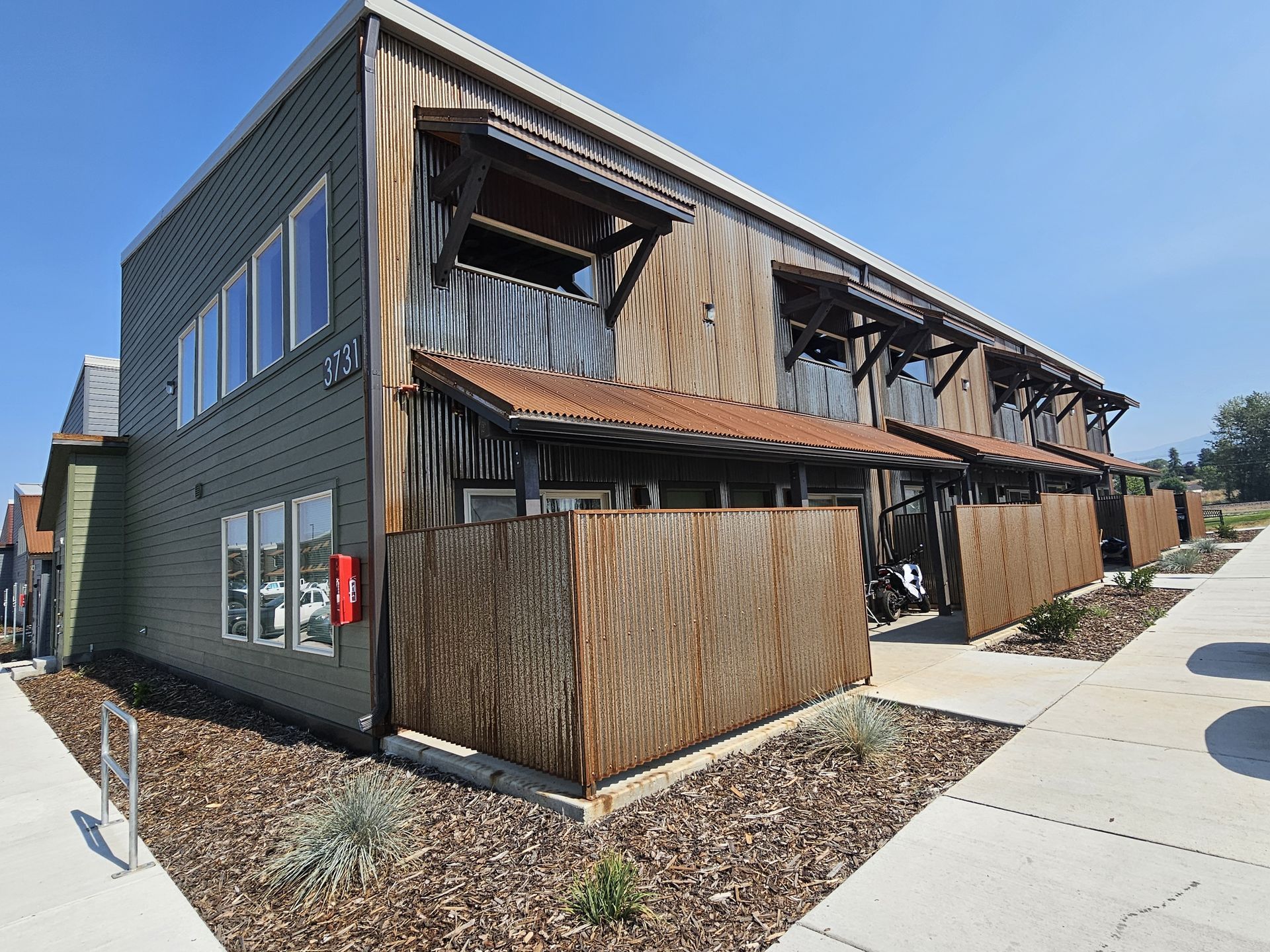 A green building with a wooden fence around it