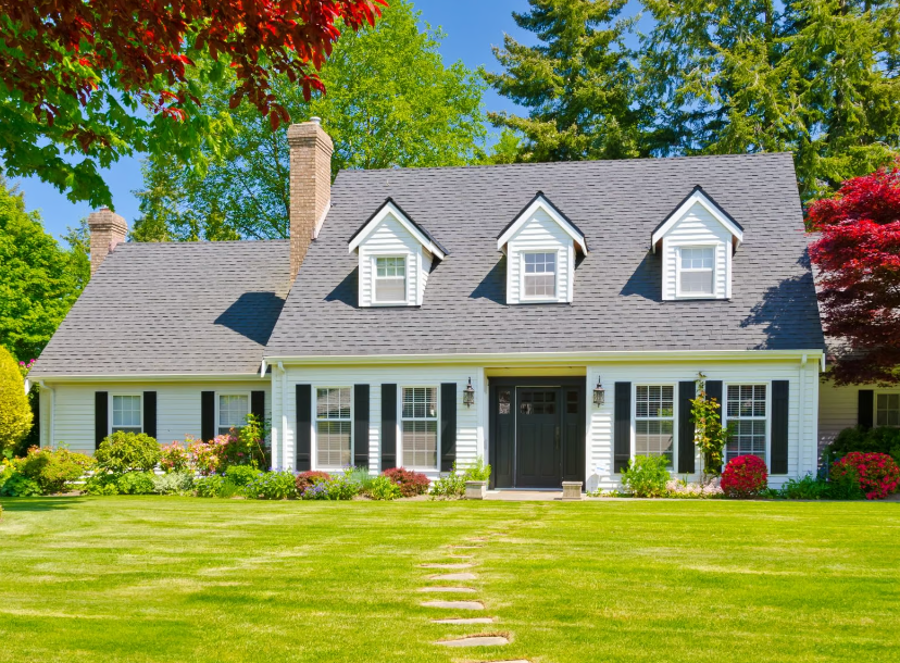 A large white house with a lush green lawn in front of it.