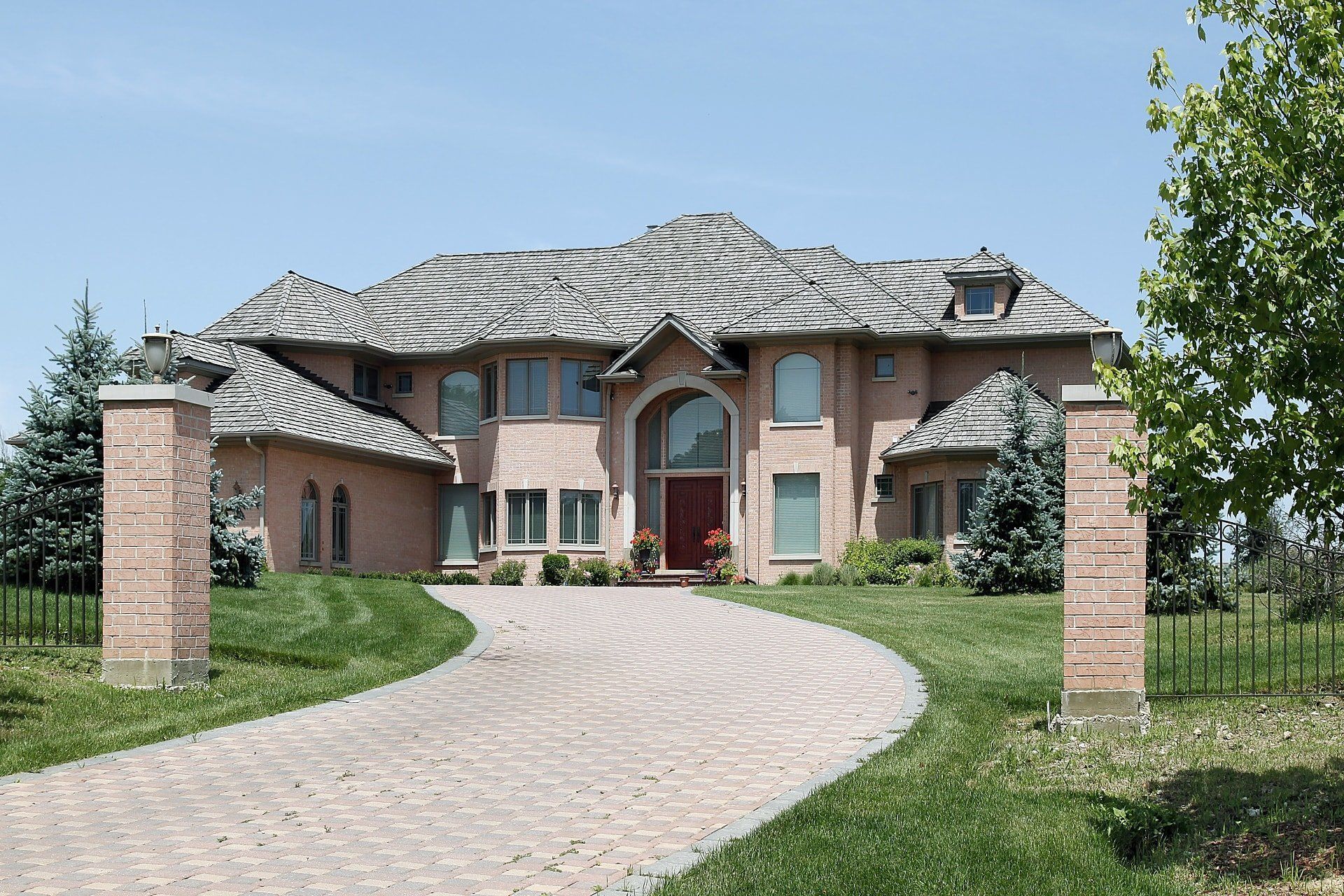A large brick house with a driveway leading to it
