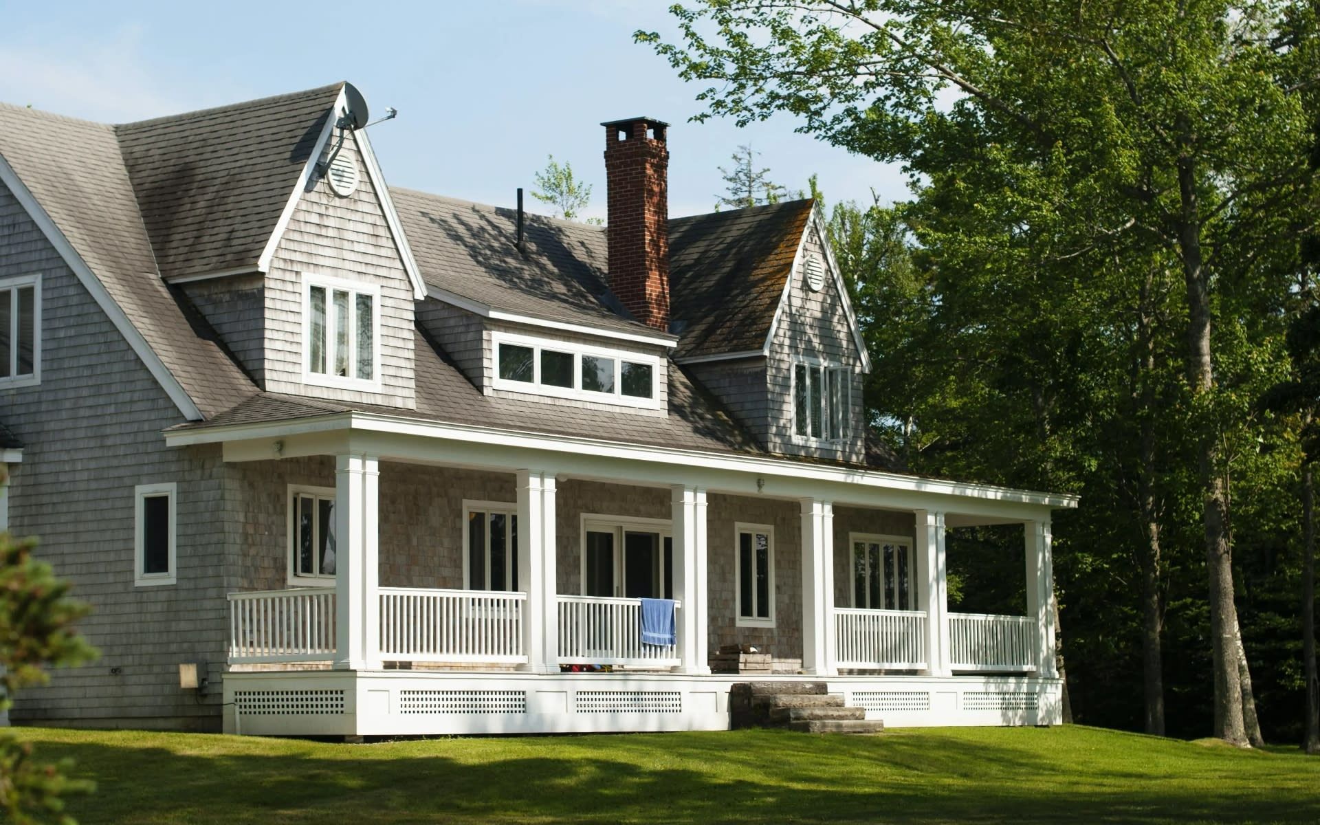 A large house with a large porch and a chimney