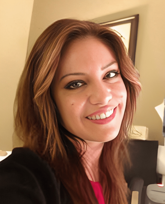 A woman with long brown hair is smiling for the camera
