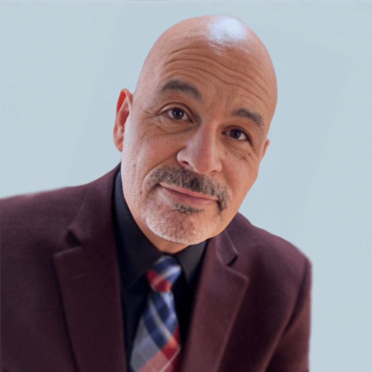 A bald man with a beard wearing a suit and tie