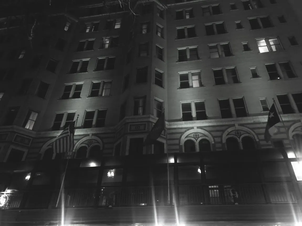 A black and white photo of a large building at night