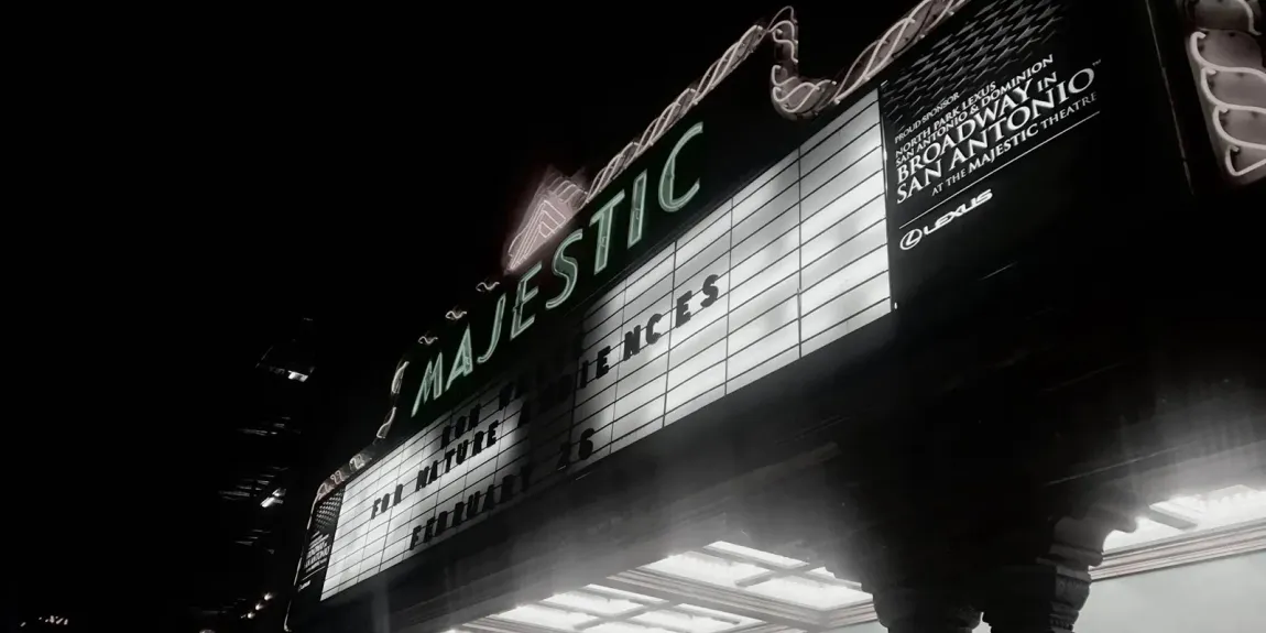 A black and white photo of a majestic theater at night.