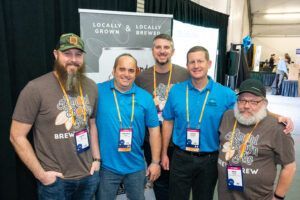 Five men in front of a banner that reads 