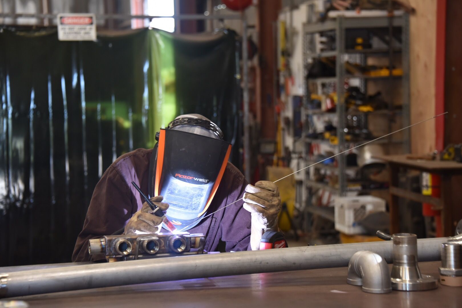 Three store employees behind a blue counter in a hardware store.