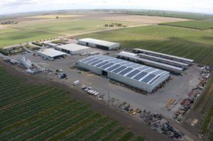 Aerial view of industrial buildings surrounded by agricultural fields.
