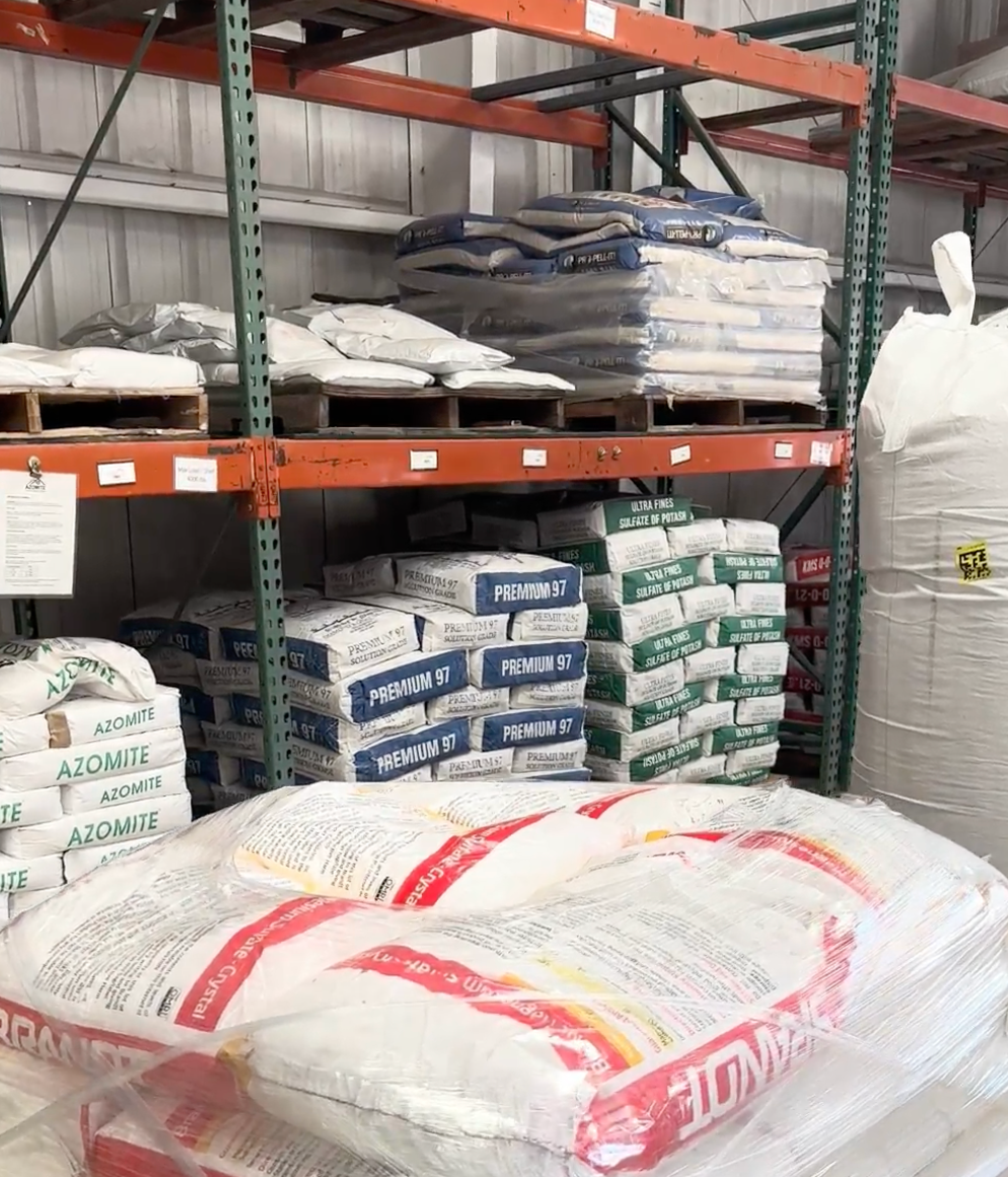 Bags of construction materials stacked on shelves in a warehouse.