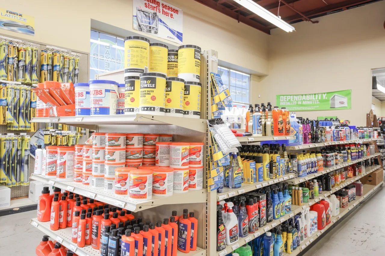 Shelves stocked with automotive products inside a hardware store; various containers and bottles.