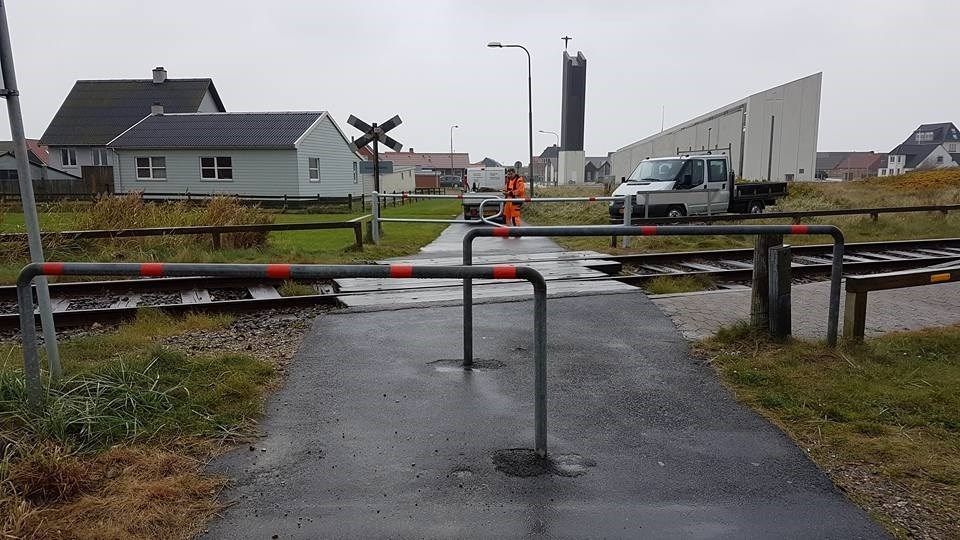 En jernbaneoverskæring med et rødt og hvidt gelænder