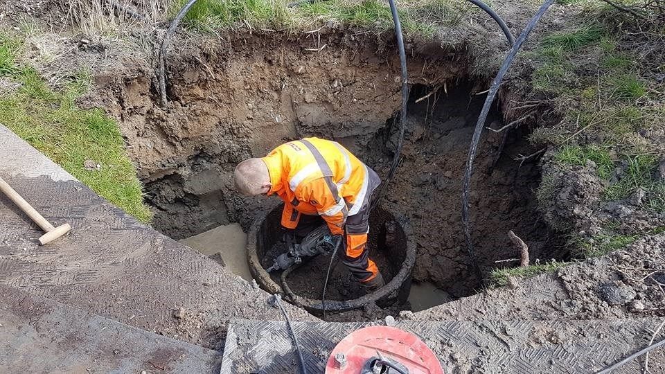 En mand arbejder i et hul i jorden.