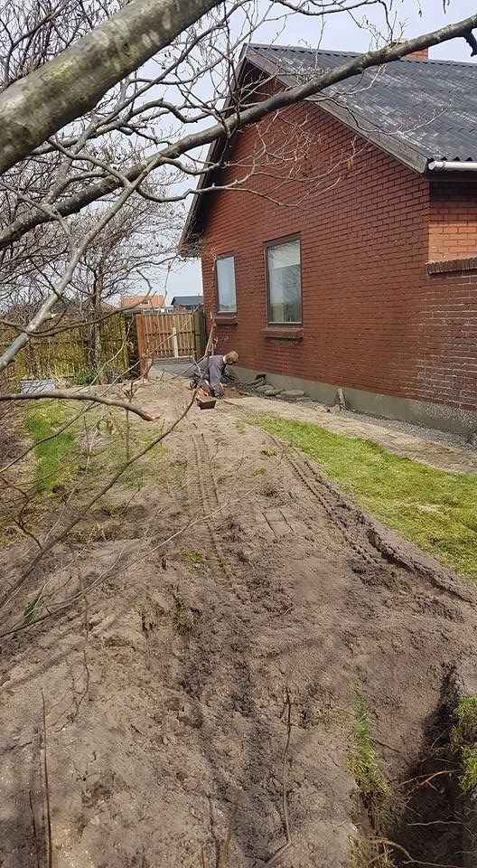 Et murstenshus med en grusvej der fører til.