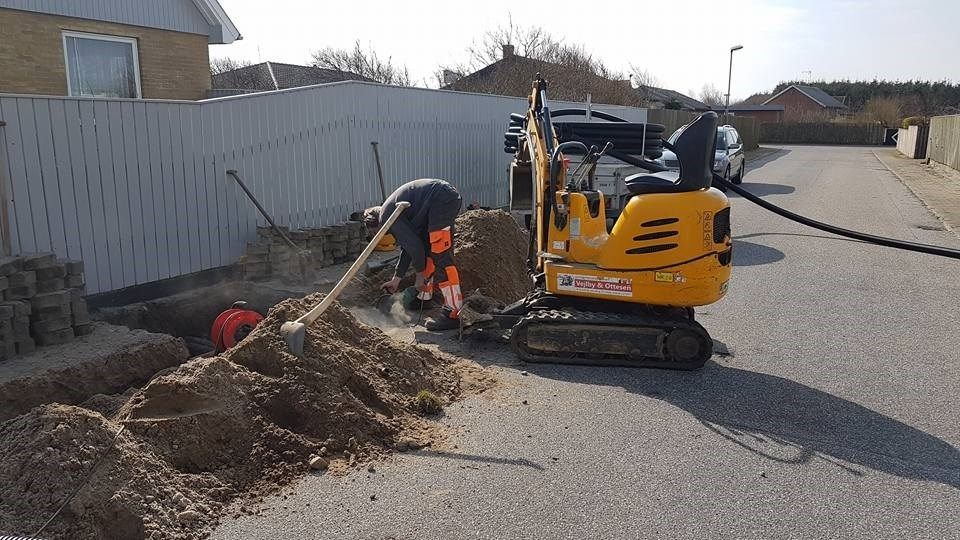 En lille gul gravemaskine bliver brugt til at grave et hul i jorden