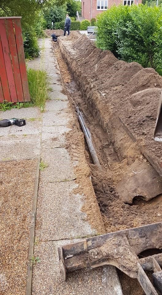 En stor bunke jord ligger ved siden af ​​et fortov.