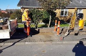 En mand står ved siden af en lastbil i siden af vejen.