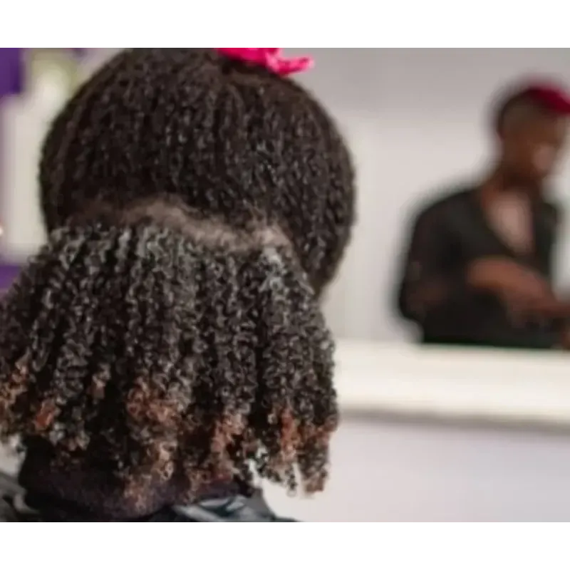 A little girl with curly hair is looking at herself in the mirror.
