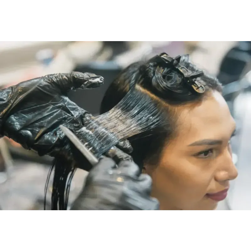 A woman is getting her hair dyed in a salon.