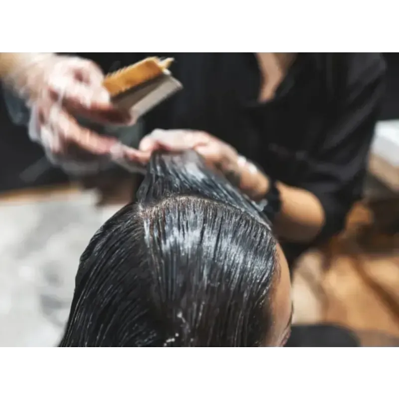 A woman is getting her hair dyed by a hairdresser.
