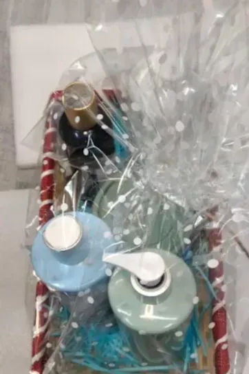 A basket filled with bottles of soap wrapped in plastic.