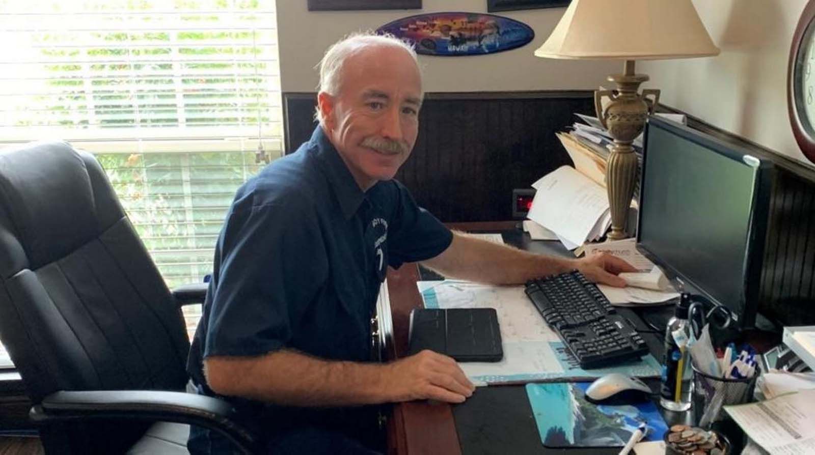 A man is sitting at a desk in front of a computer.