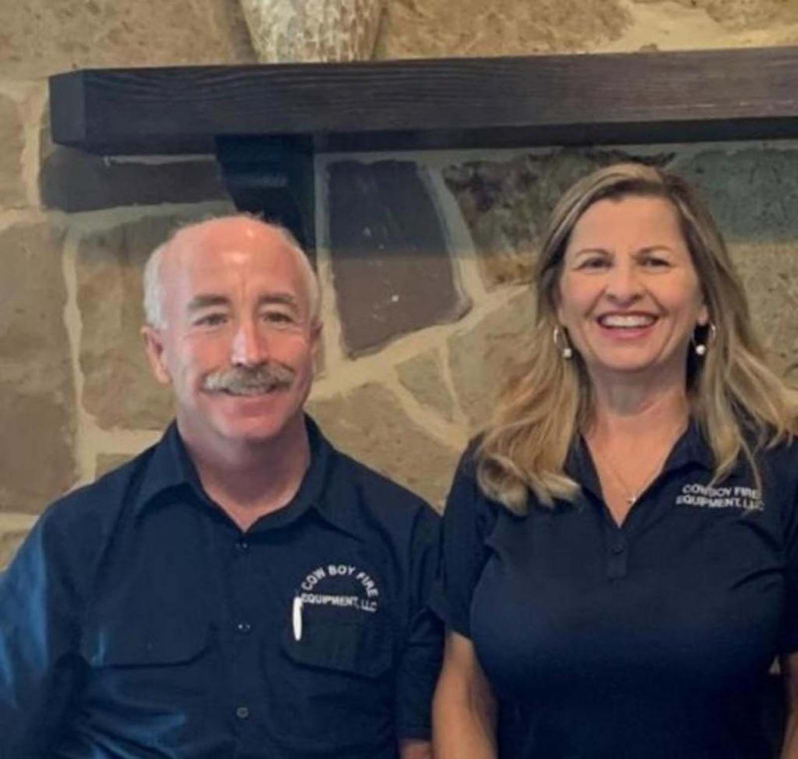 A man and a woman are posing for a picture and the man has a mustache