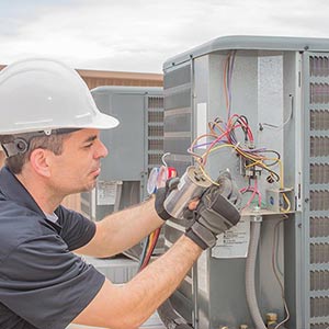 Technician Holding Capacitor — AC Repair Williamsburg in Yorktown, VA