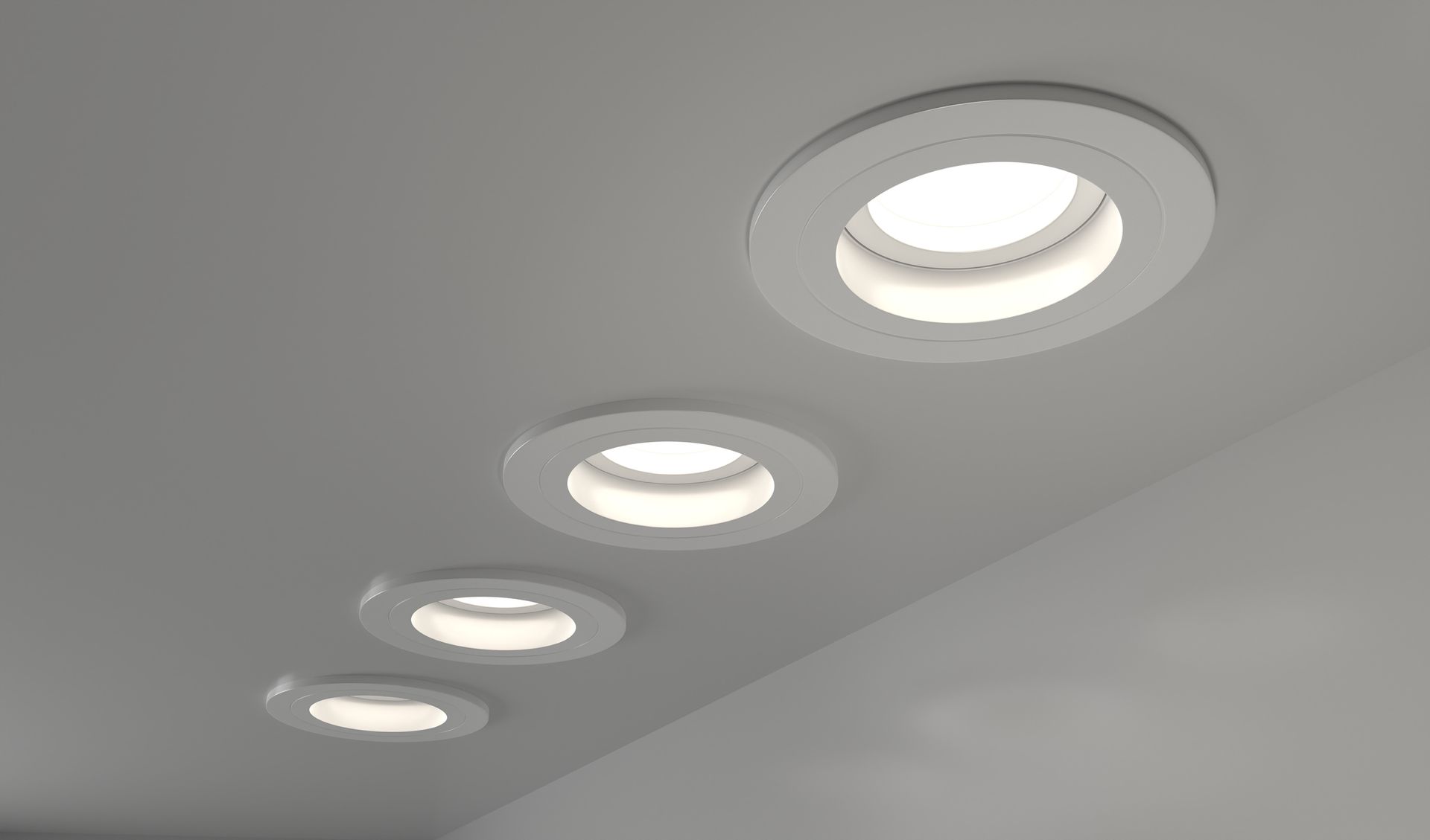 A row of recessed lights are lined up on a ceiling.