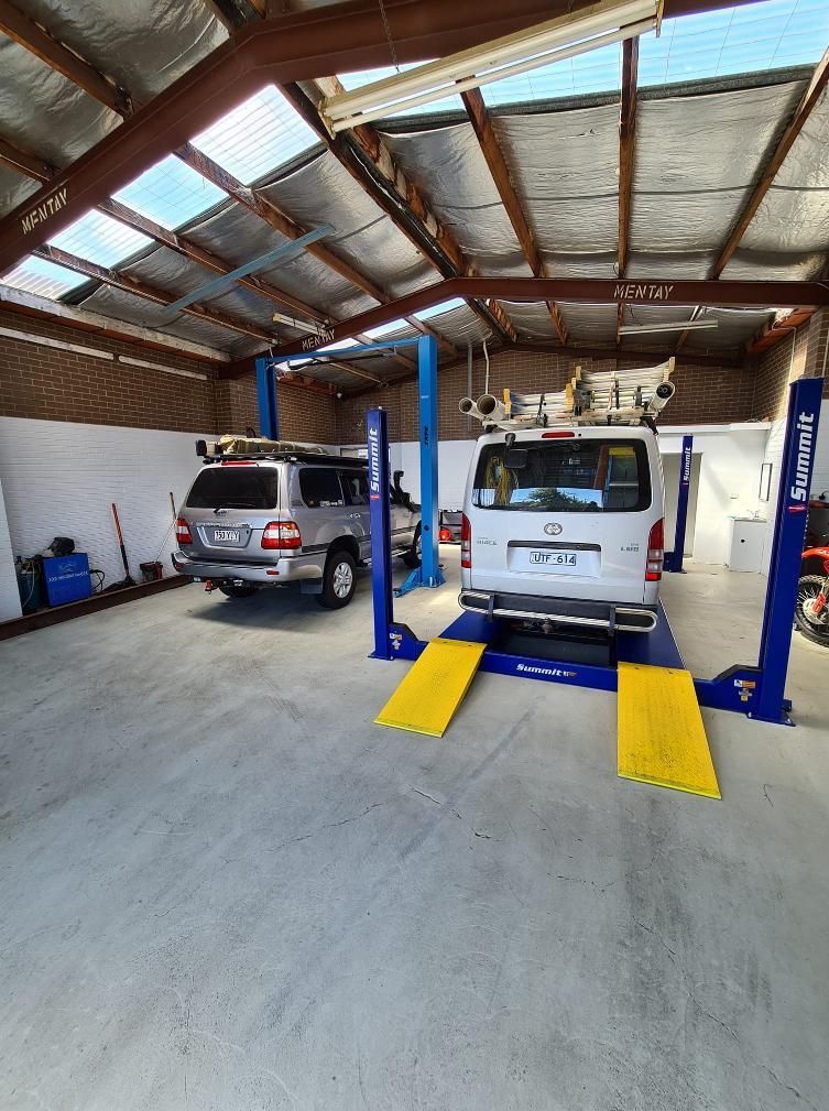 Two Cars Are Sitting On A Lift In A Garage — COOTA Automotive Services In Ballarat East, VIC
