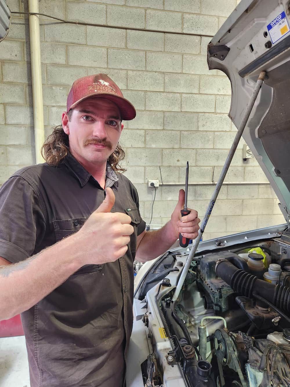 A Man Is Standing In Front Of A Car With The Hood Open And Giving A Thumbs Up — COOTA Automotive Services In Ballarat East, VIC