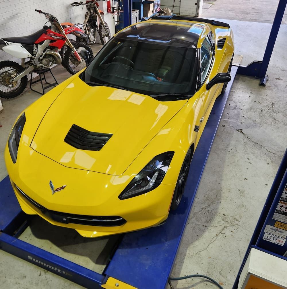 A Yellow Sports Car Is On A Lift In A Garage — COOTA Automotive Services In Ballarat East, VIC