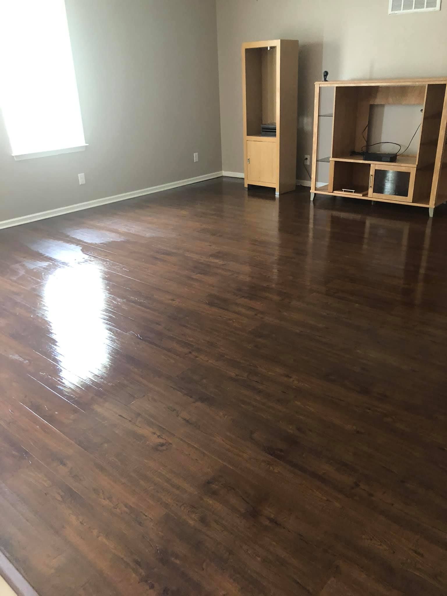 A room with dark wood flooring, light grey walls, and two wooden furniture units.