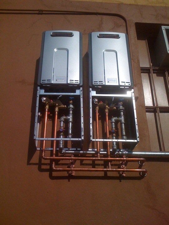 Two water heaters with copper pipes attached to them