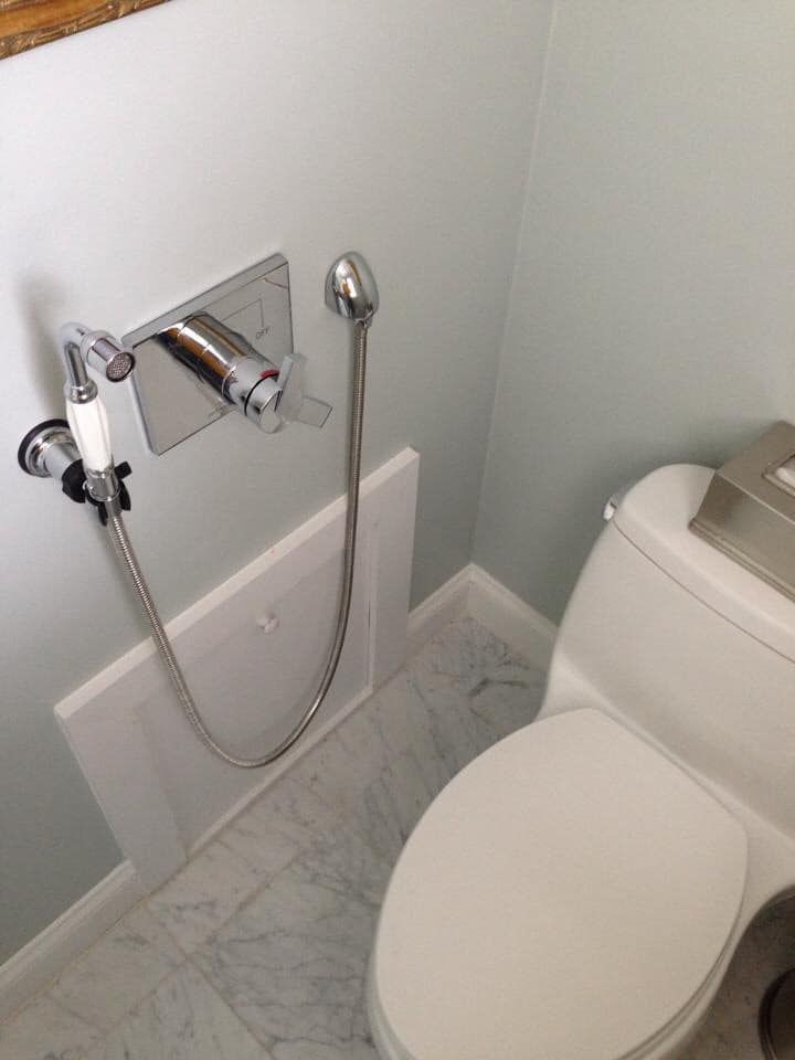 A toilet with a bidet attached to it