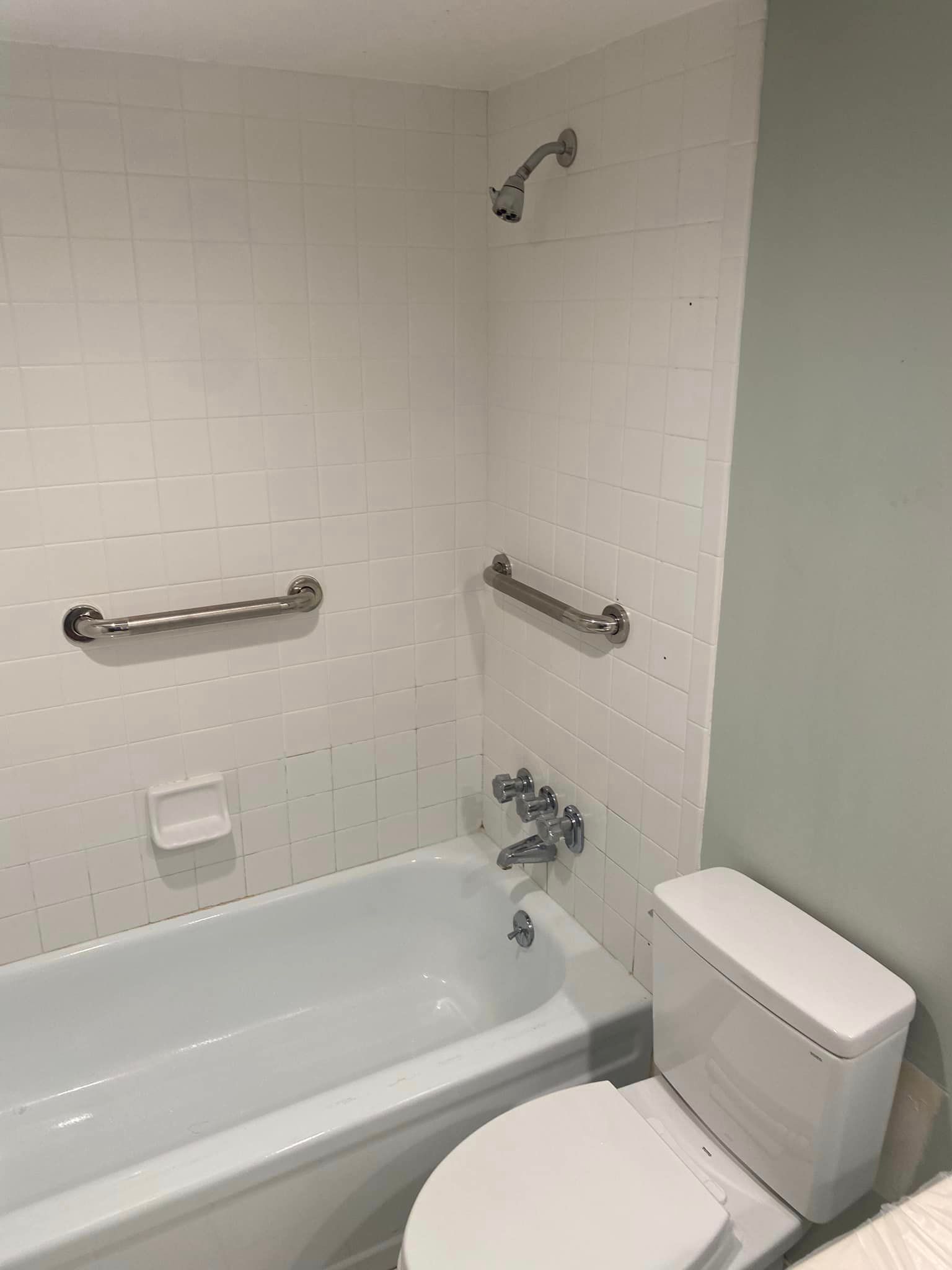 A bathroom with a tub , toilet and shower.