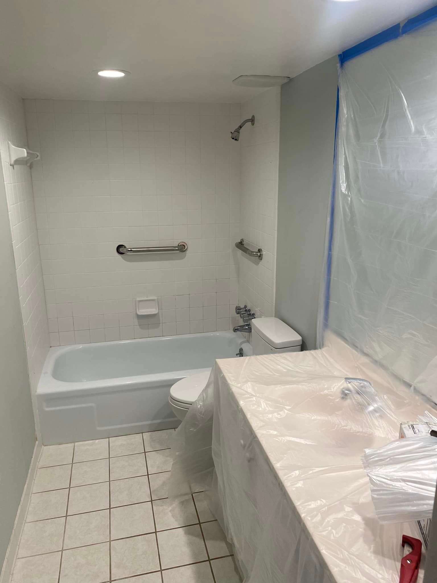 A bathroom with a tub , toilet , sink and shower.