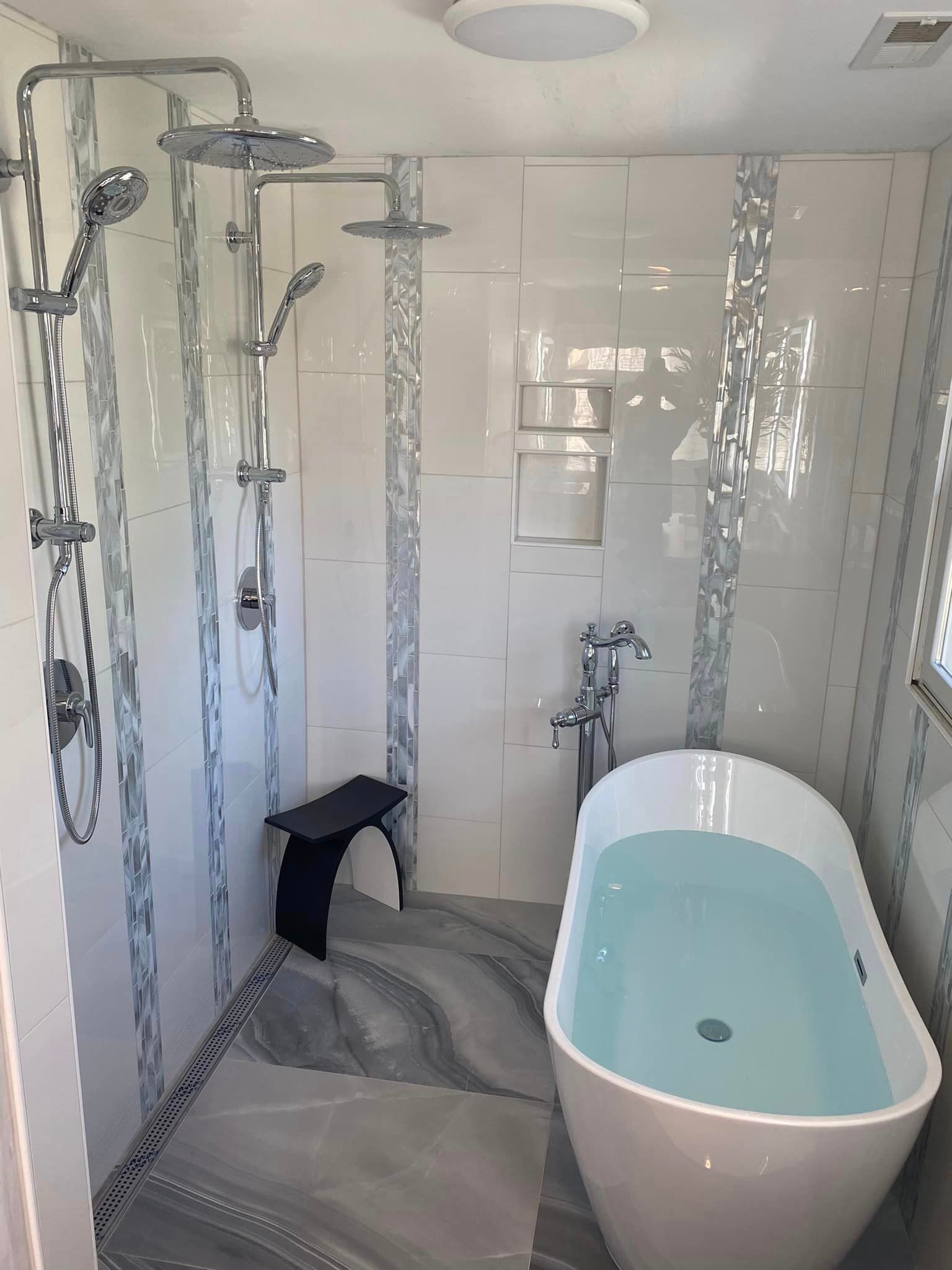 There is a bathtub in the bathroom with a shower.