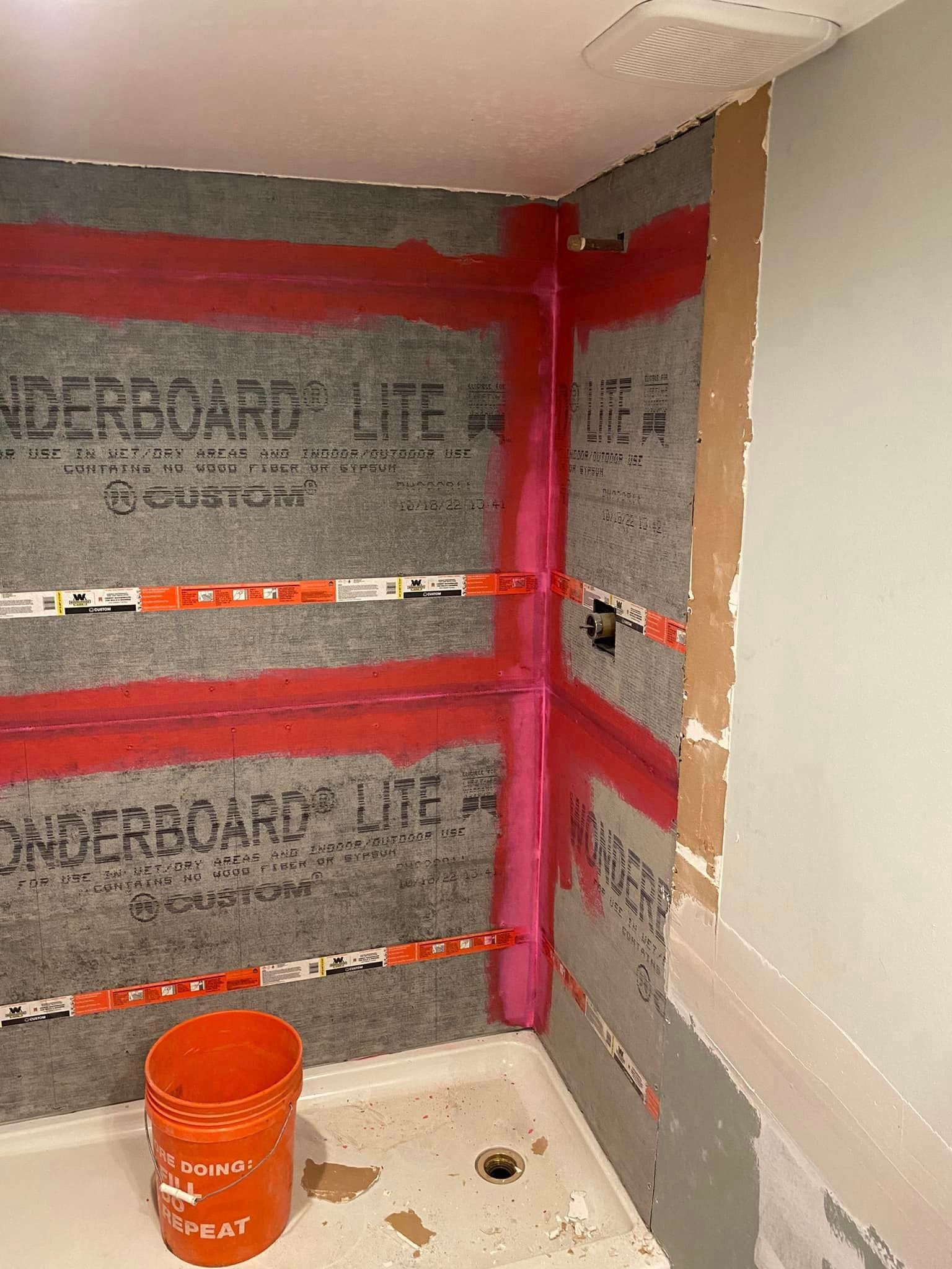 A bathroom with a bucket on the floor and a bucket on the floor.