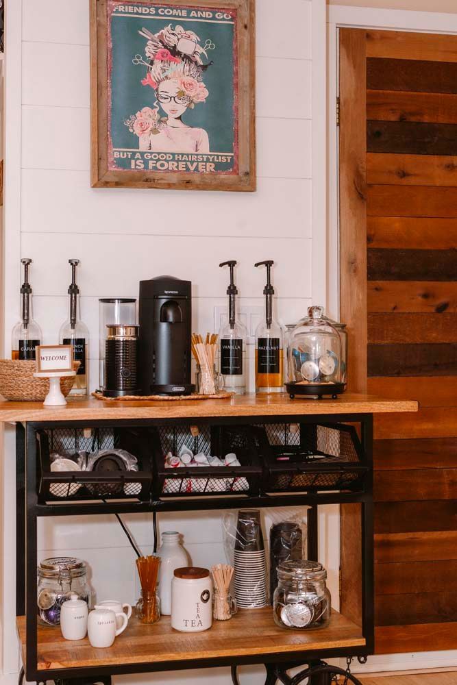 A coffee bar with a picture of a woman on the wall above it.