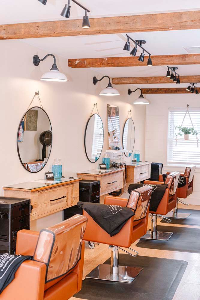 A hair salon with a lot of chairs and mirrors.